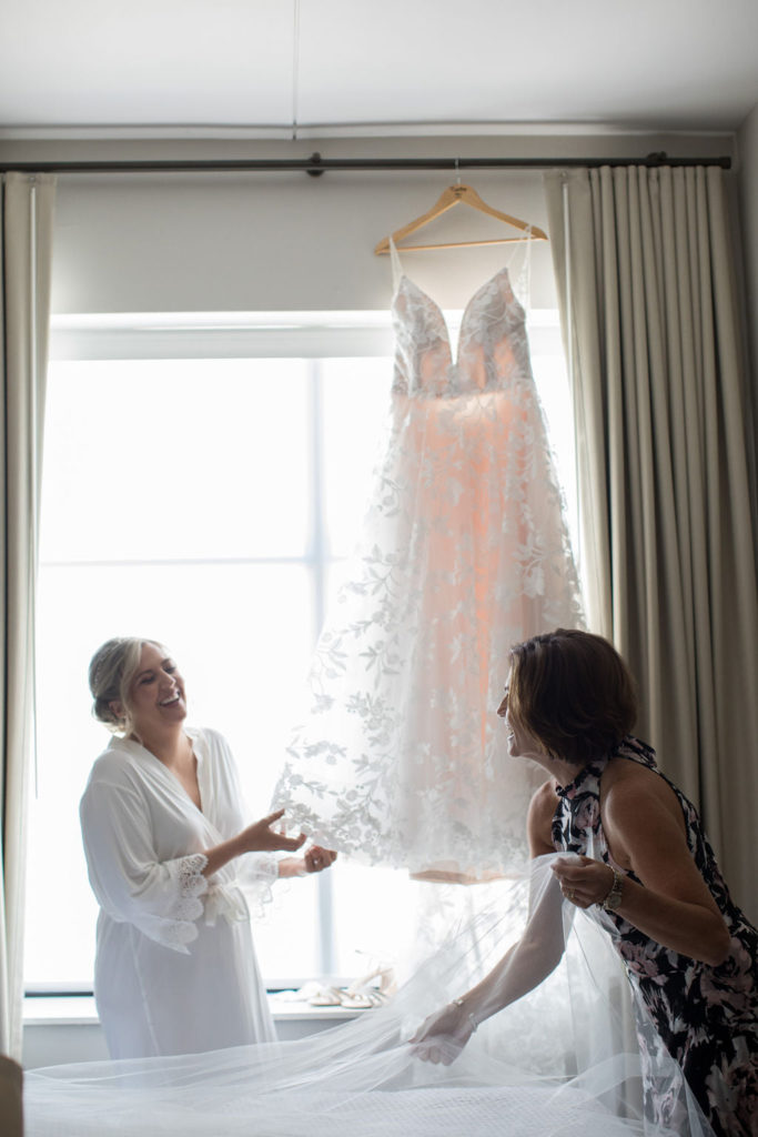 bride and mom looking at wedding dress