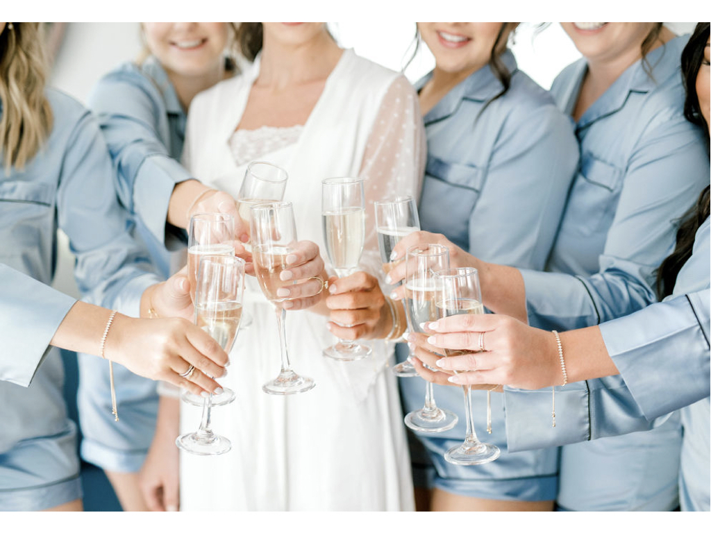 Bride and bridesmaids toast while getting ready