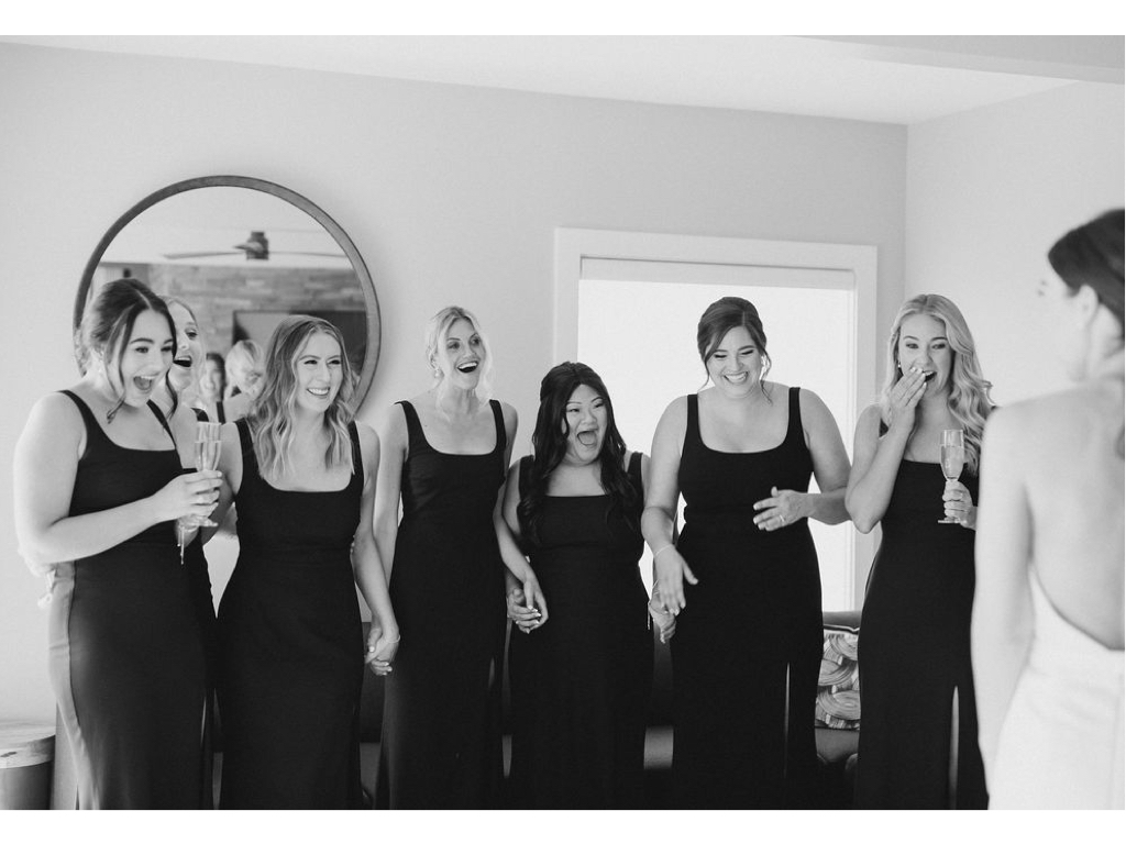 Bridesmaids see their friend, the bride, in her wedding dress for the first time